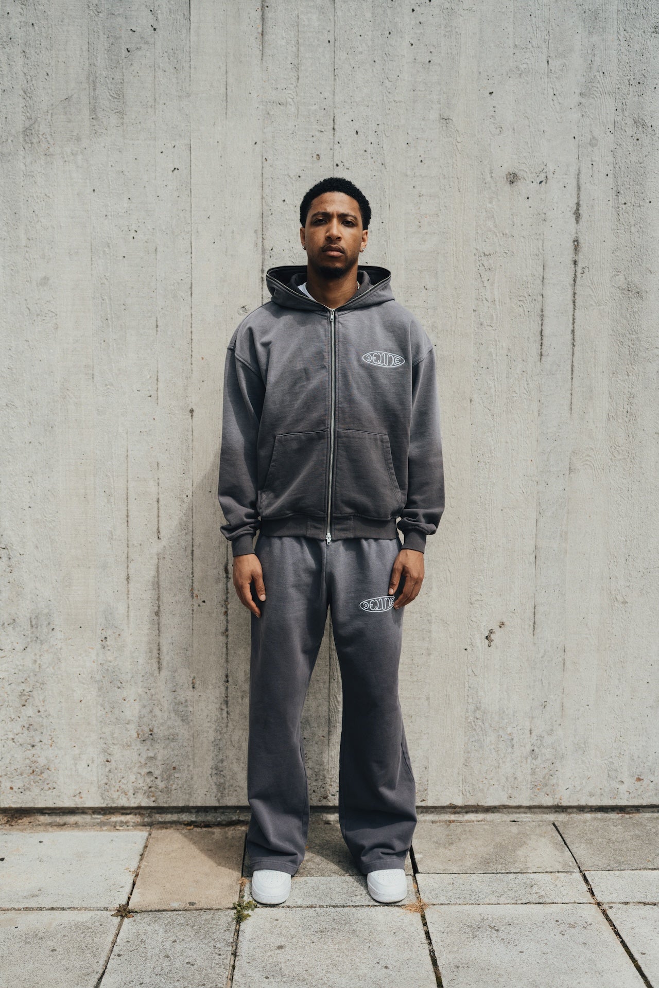 Model wearing 1Deluxe Grey Fade Joggers with matching grey zip-up hoodie